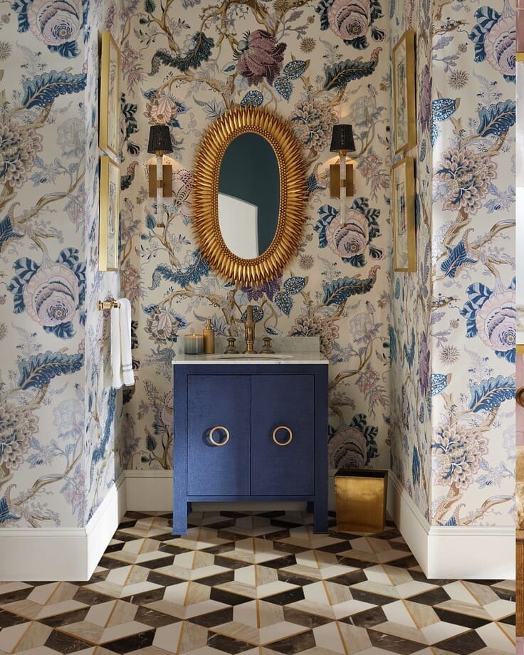 Bold floral bathroom wallpaper with a navy vanity and gold mirror