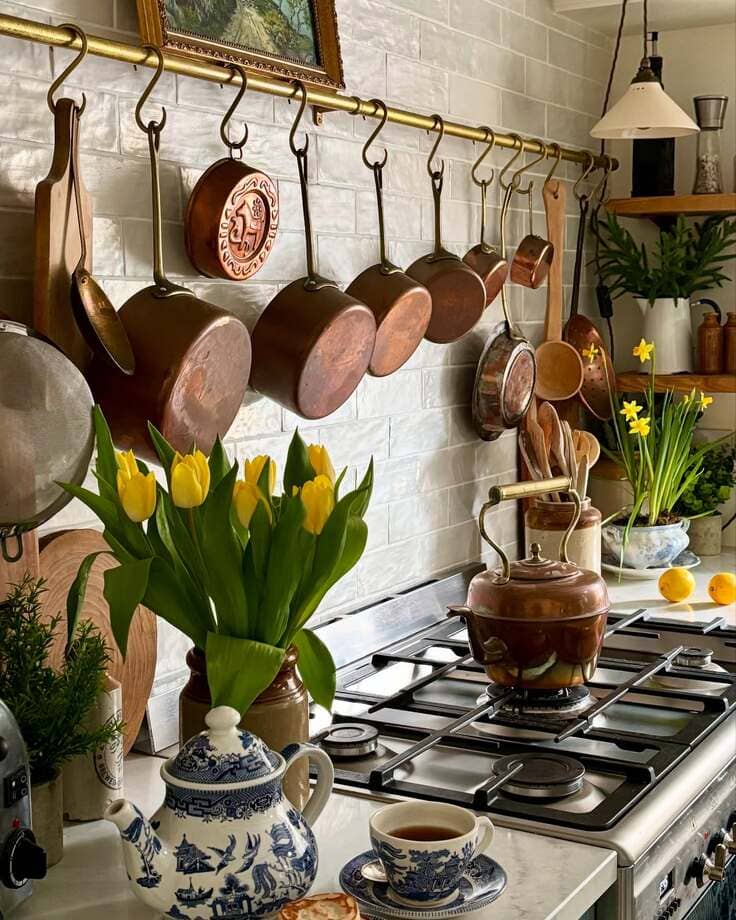 Cozy French country kitchen with hanging copper pots and yellow tulips