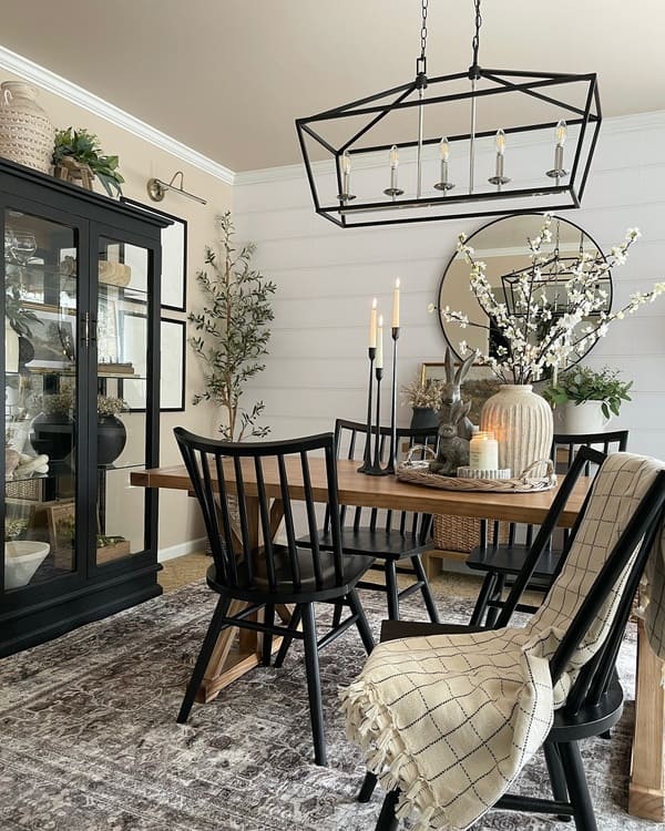 Black spindle chairs and rustic wood table in a cozy farmhouse dining room