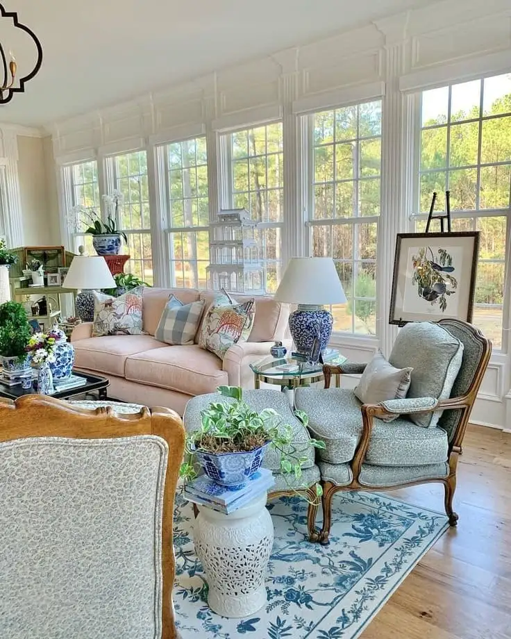Traditional sunroom with pastel sofa, chinoiserie accents, and floor-to-ceiling windows