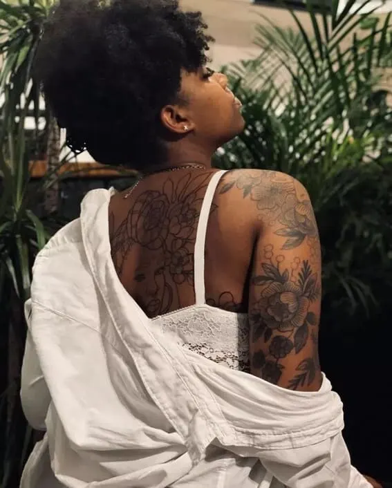 woman with full sleeve of rose tattoos on her arm