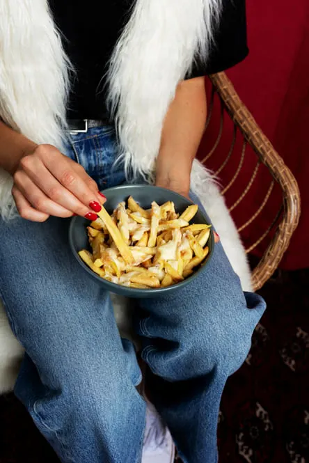 Intermittent Fasting for dopamine, Portrait of woman enjoying a dish of poutine 