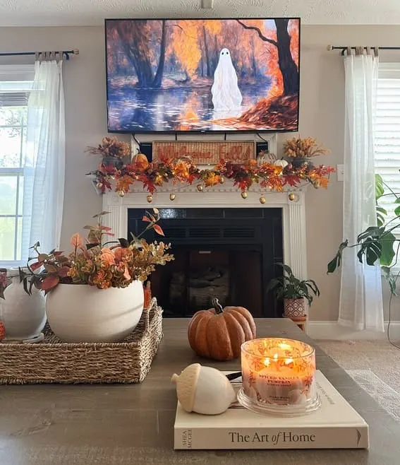 Warm fall mantel decor with vibrant leaves and pumpkins.