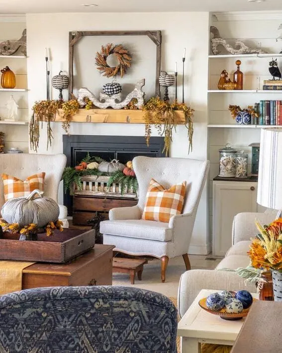 Cozy fall mantel decorated with gingham pumpkins, cascading greenery, and rustic touches.