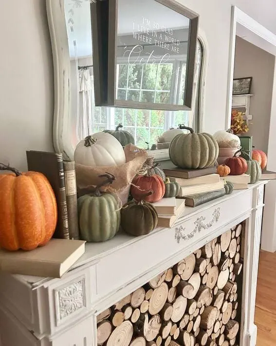 Fall mantel with stacked pumpkins, vintage books, and cozy autumn decor.