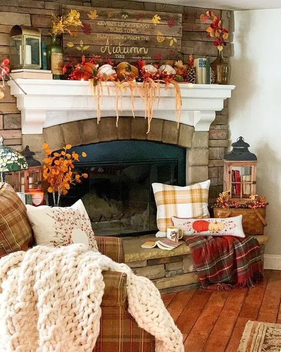 Fall mantel with pumpkins, plaid accents, and autumn-themed decor.