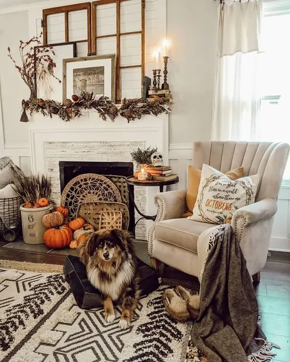 A cozy fall mantel with rustic garland, vintage window frames, and warm seasonal accents, including a charming dog lying nearby.